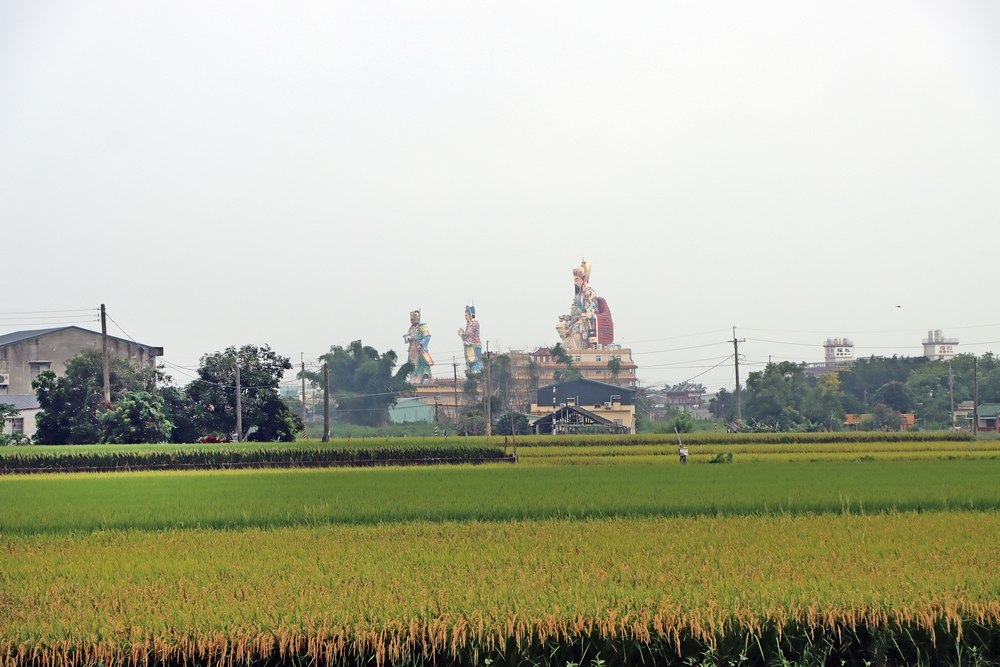 在田野間眺望開元殿鄭成功與甘輝萬禮雕像 ©曾令愉/旅讀